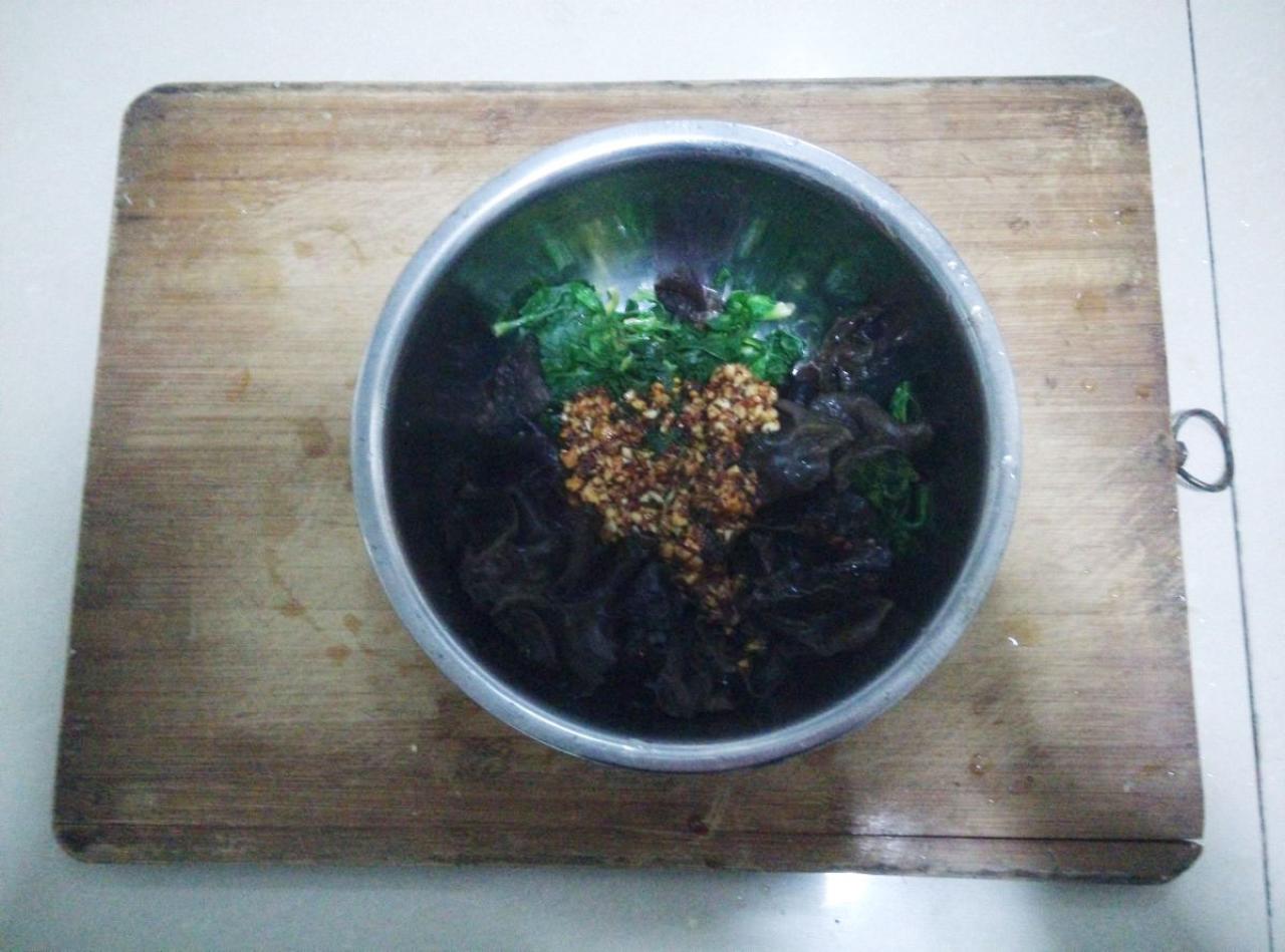 搅拌菠菜、木耳和辣椒油调料