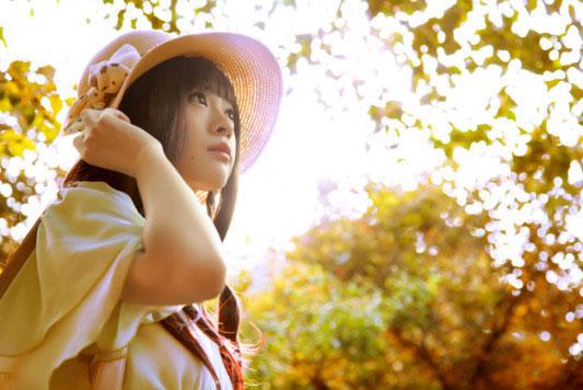 溢灯灯扶着草帽仰望透过林荫的天空