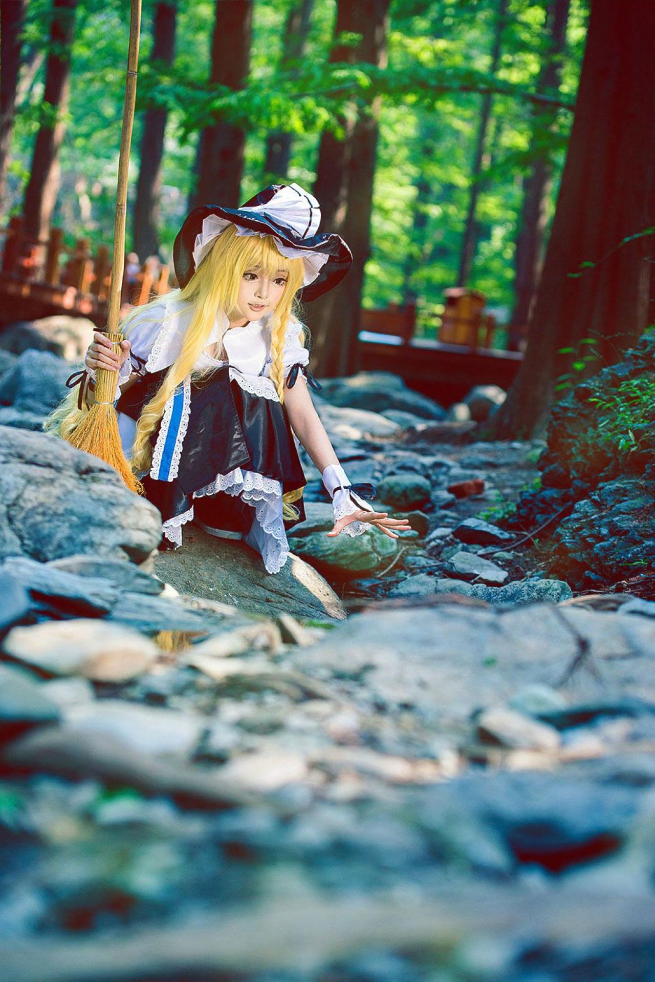 雨扮演雾雨魔理沙右手握着扫把，左手五指张开，要抓的姿势