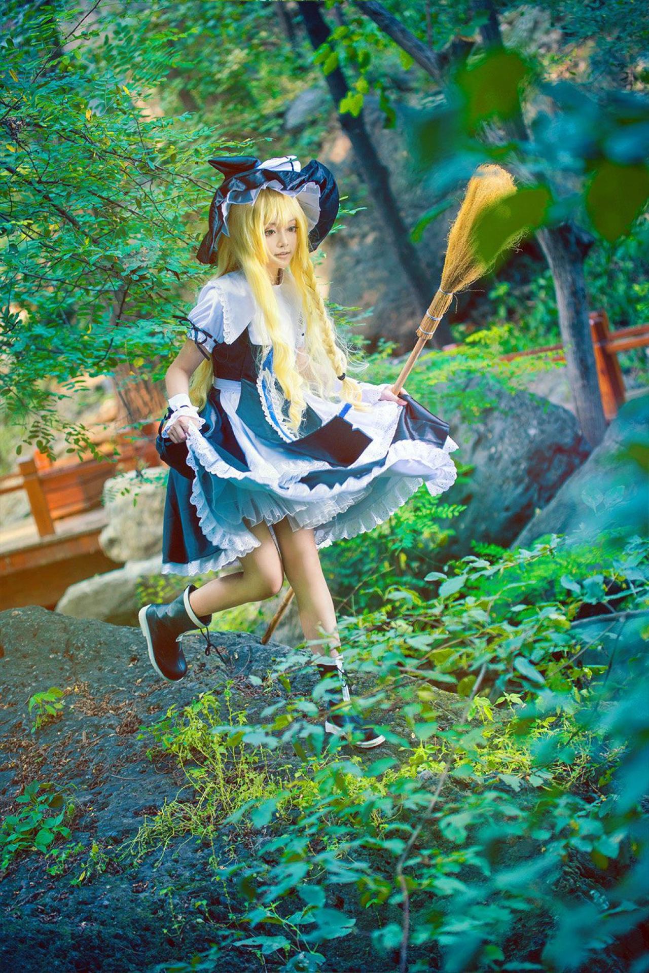 雨扮演雾雨魔理沙双手撑起裙角，即将步入水中的姿势