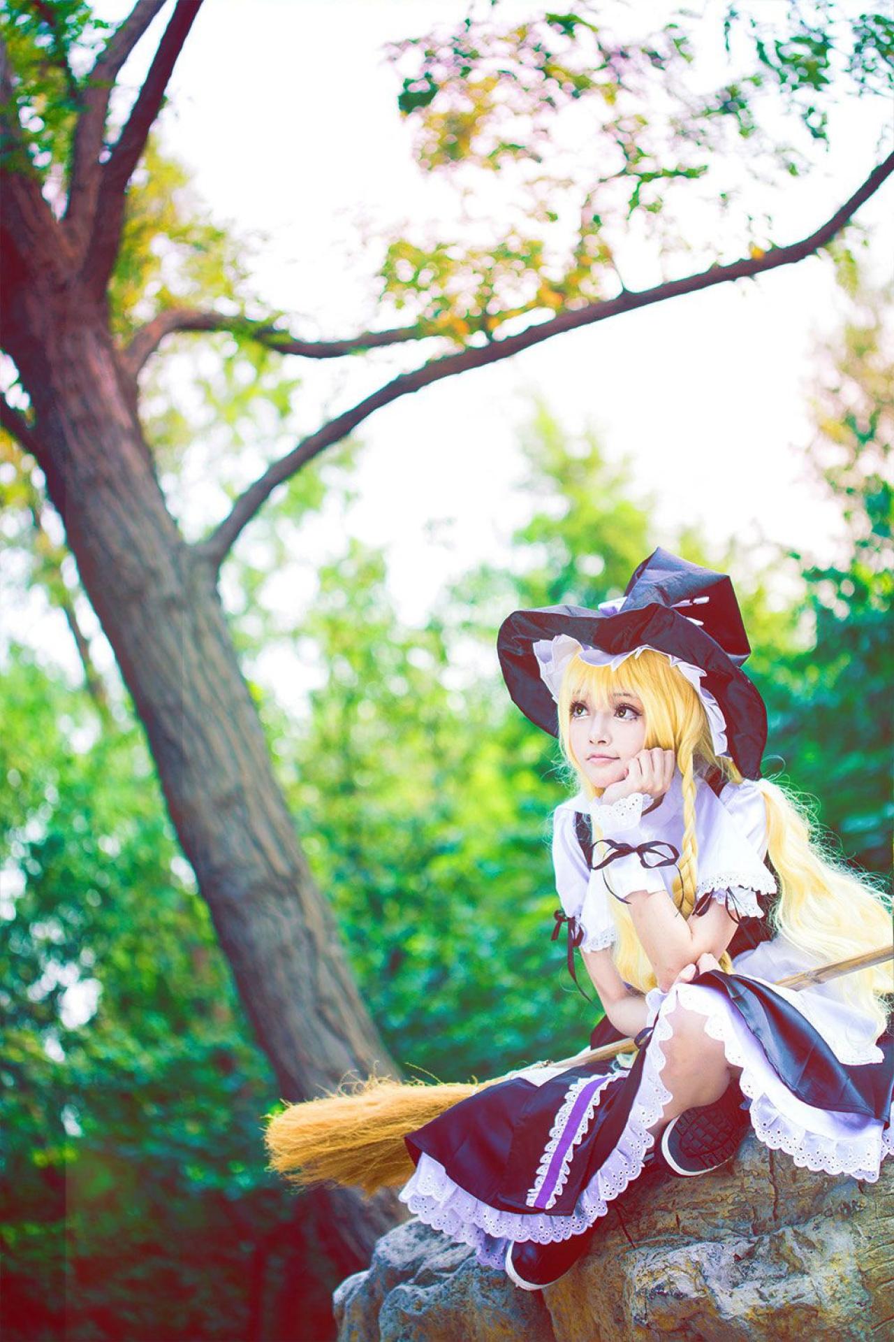 雨扮演雾雨魔理沙，盘腿坐在树荫下的石头上，右手搭在膝盖上，撑着左手扶着下巴，思考的神情