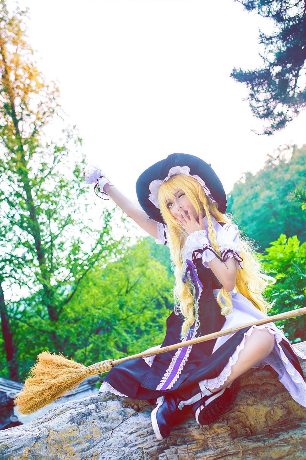 雨扮演雾雨魔理沙，盘腿坐在石头上，扫把放在膝间，抬起右臂，左手遮住嘴边，打着哈欠，伸懒腰的姿势