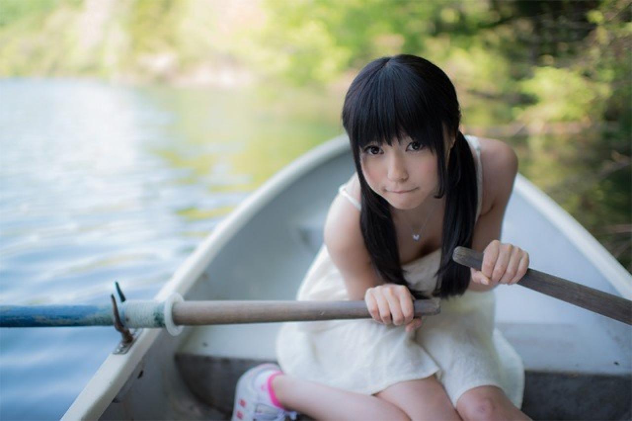 小出友华双手撑着船桨，咬着嘴唇努力划船的样子