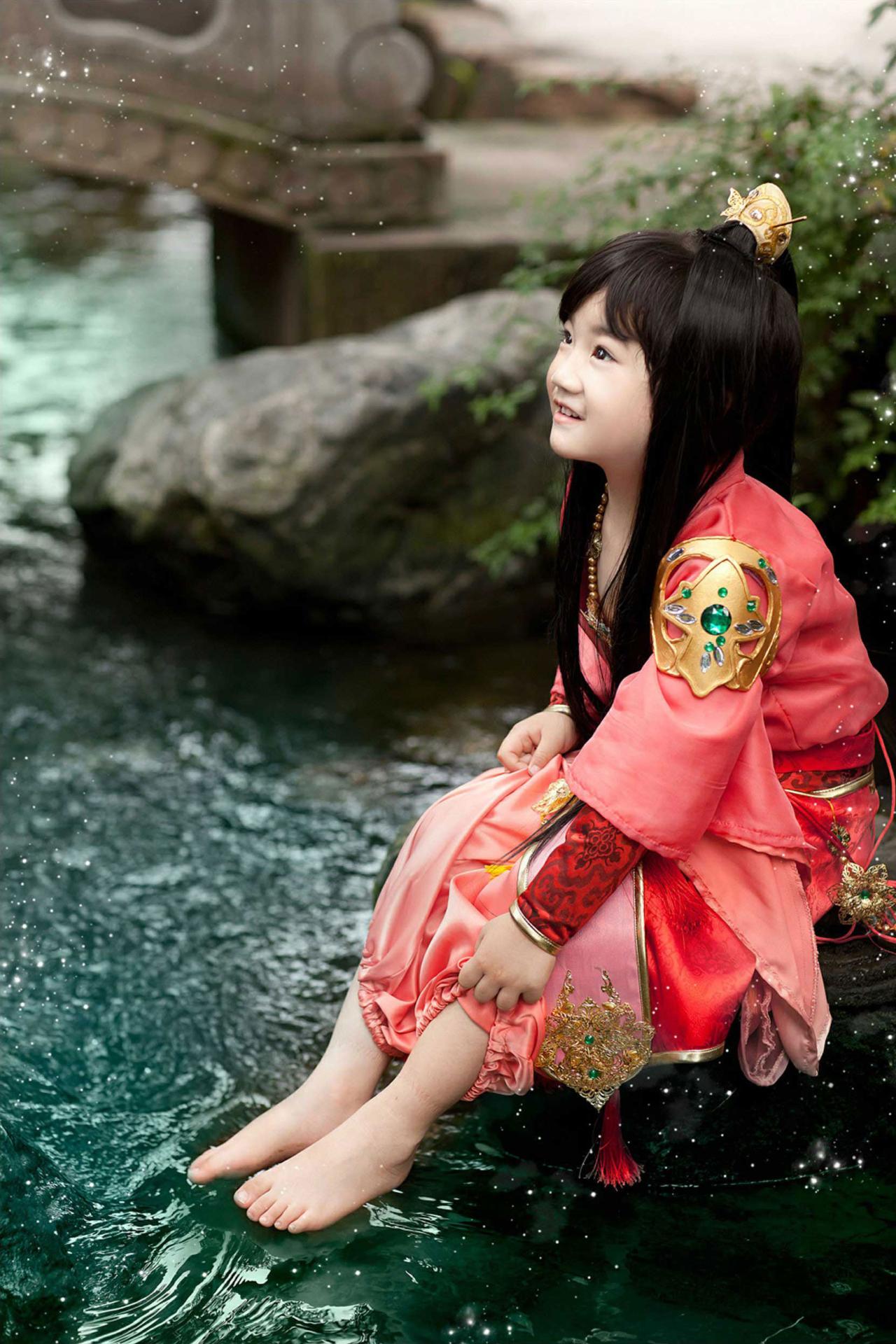 陈小猪扮七秀正太坐在水旁的石头上