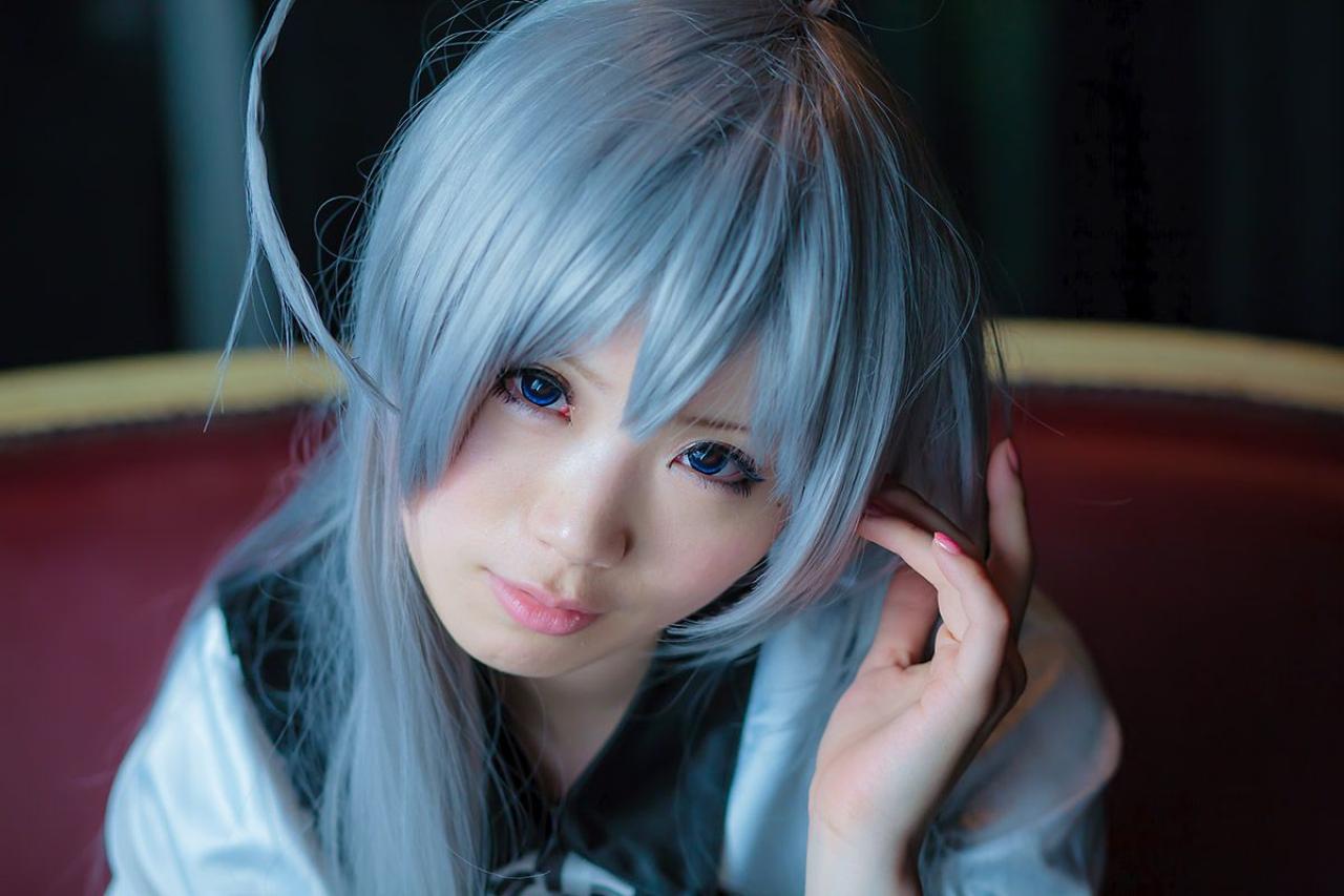 倉坂くるる歪着头，左手的手指抵着太阳穴