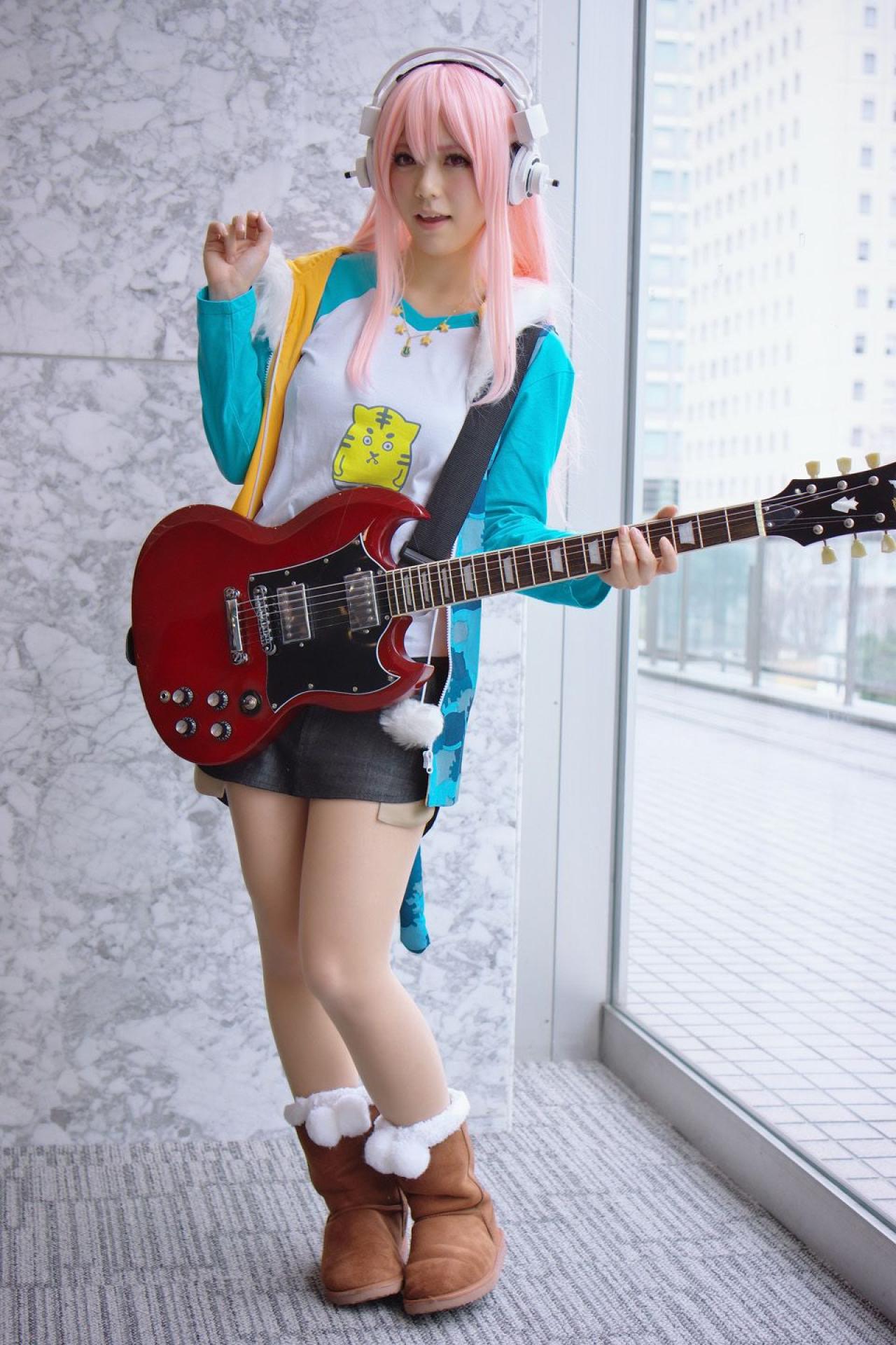 春宮ゆん扮超级索尼子左手按着吉他，抬起右手