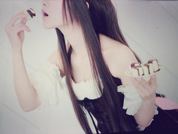 とめと左手端着盘子，右手正将一块蛋糕送进嘴里