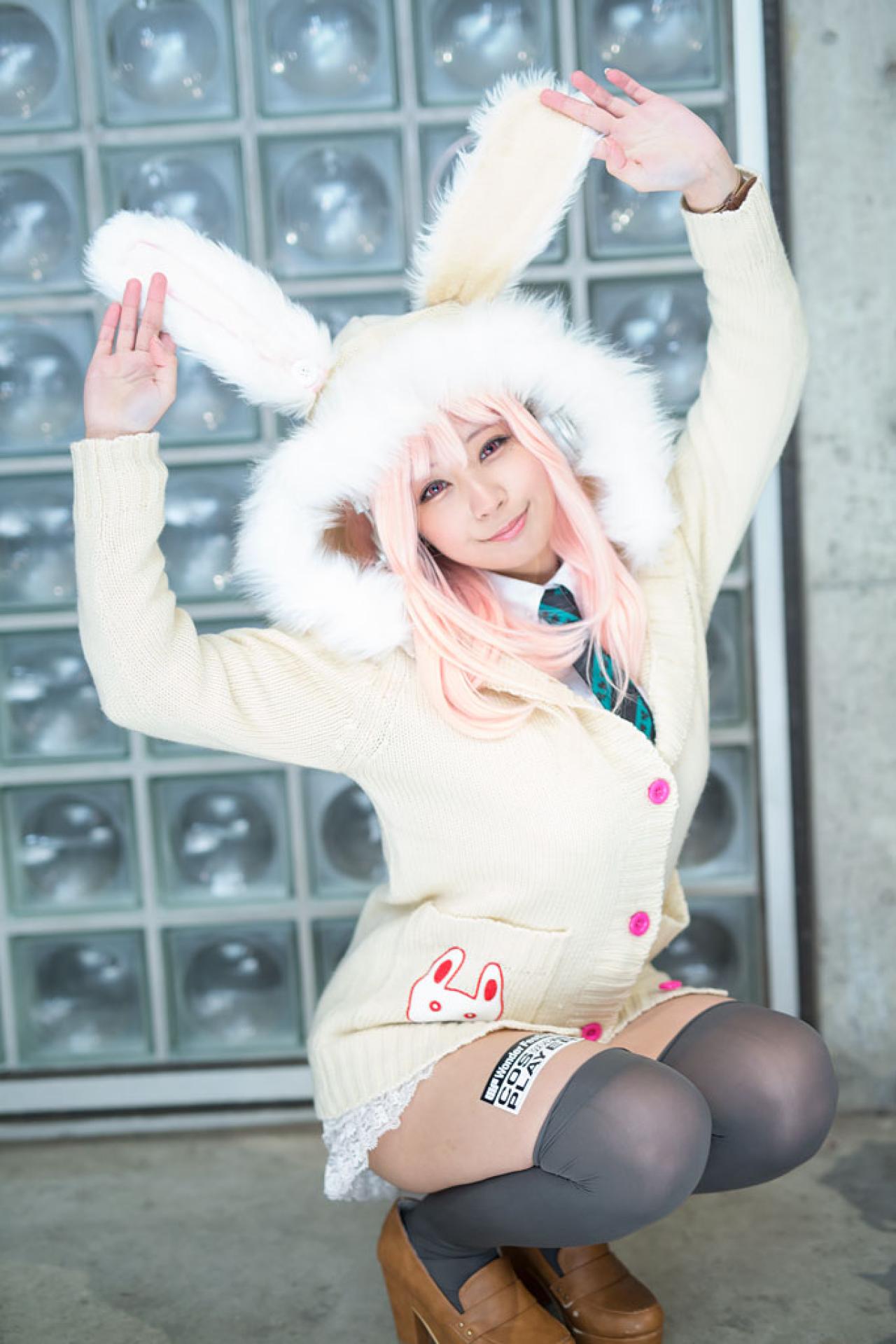 です扮超级索尼子戴着兔耳帽子，双手撑起兔耳，蹲姿