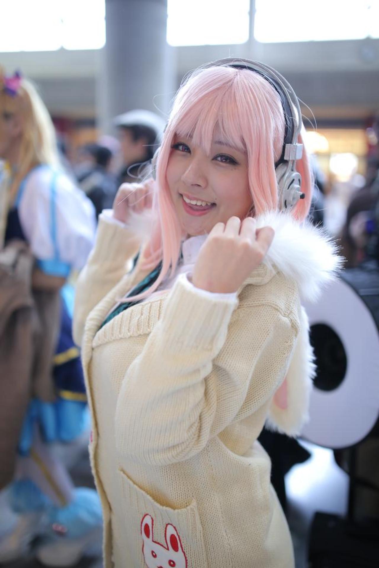 です扮超级索尼子双手抓着帽檐，侧身微笑