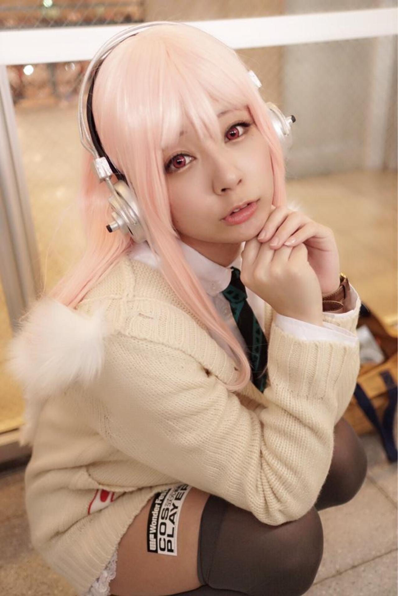 です扮超级索尼子双手扣在一起，撑着下巴，蹲姿