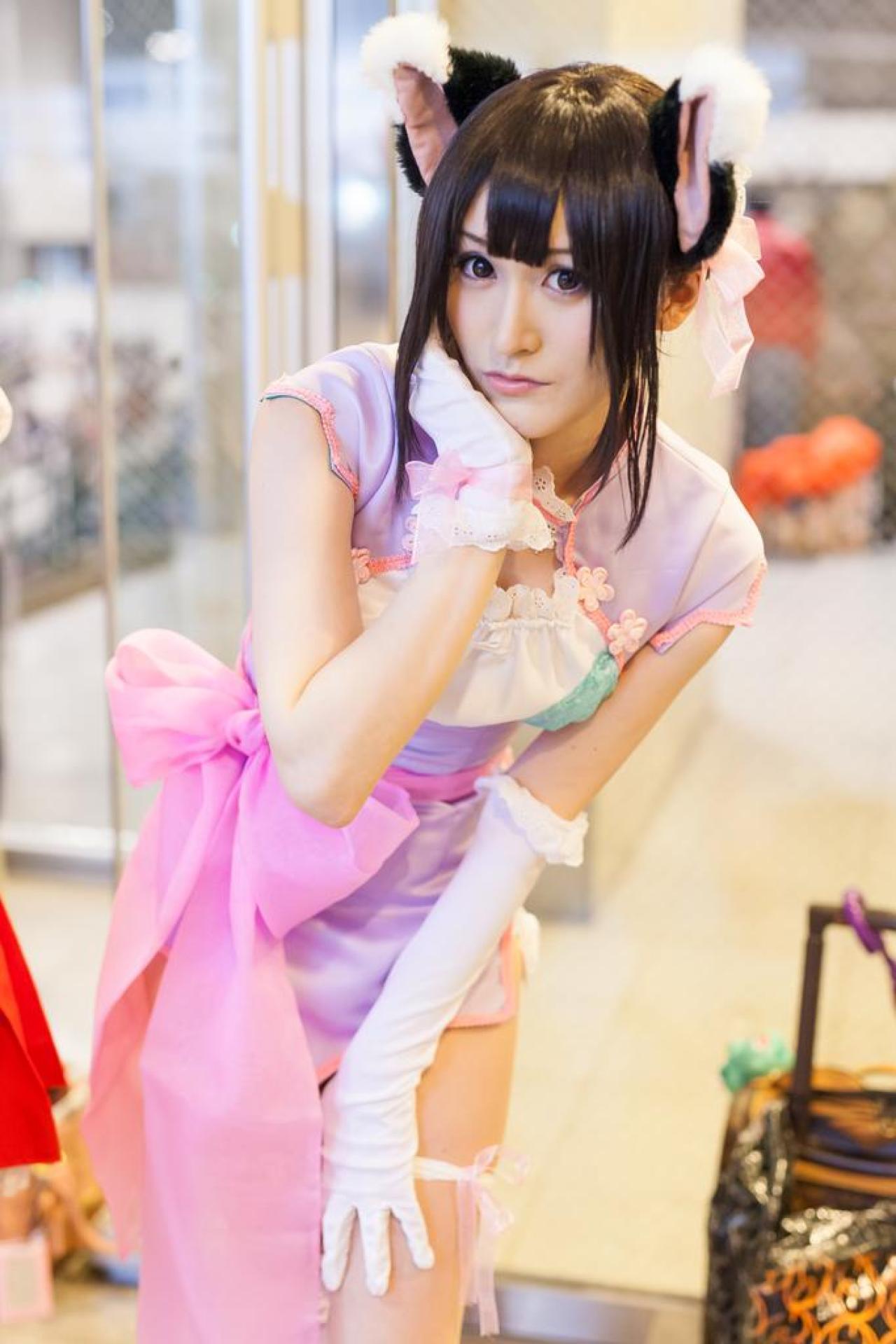 にゃるまー扮小梅前倾身子，右手扶着下巴，左手撑着膝盖，站姿