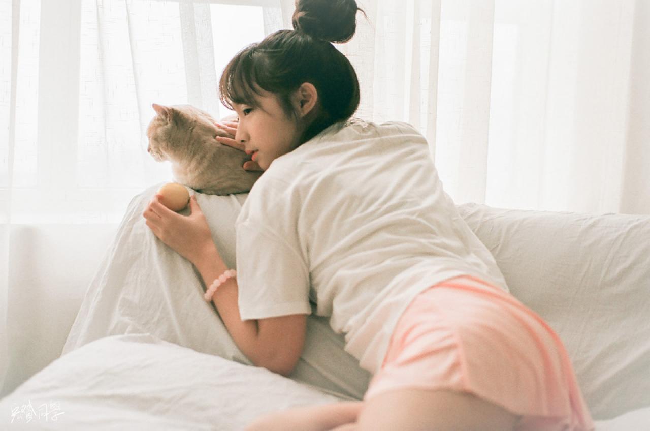 猫咪转过头去，戴钰拿着柠檬，抚摸猫咪的侧脸