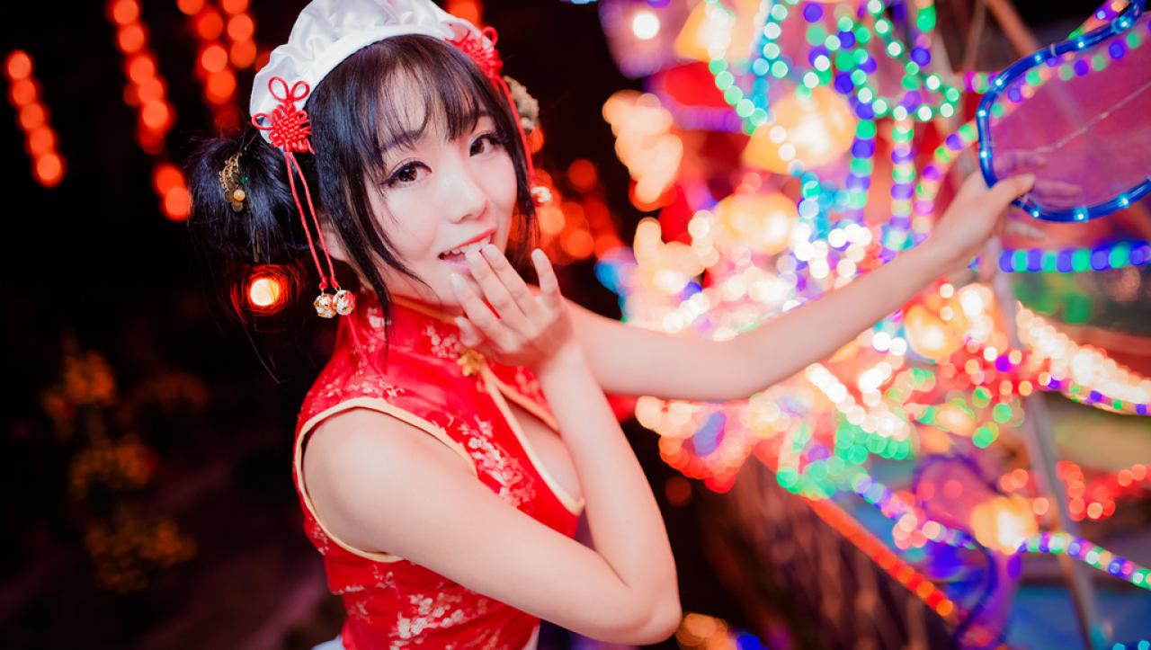 小灵左手扶着彩灯，右手扶在嘴角