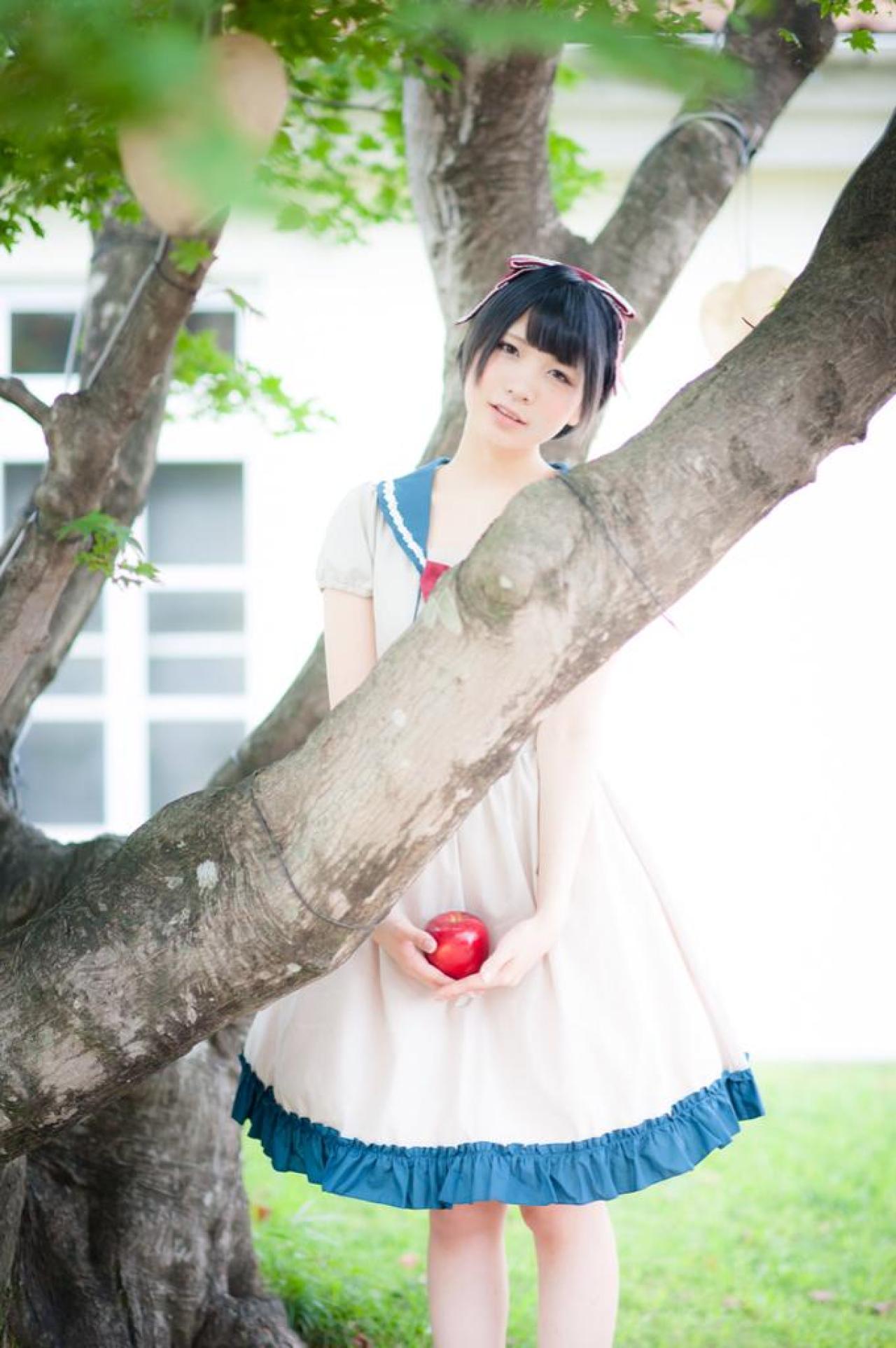 Panzerella双手捧着苹果，在树干后