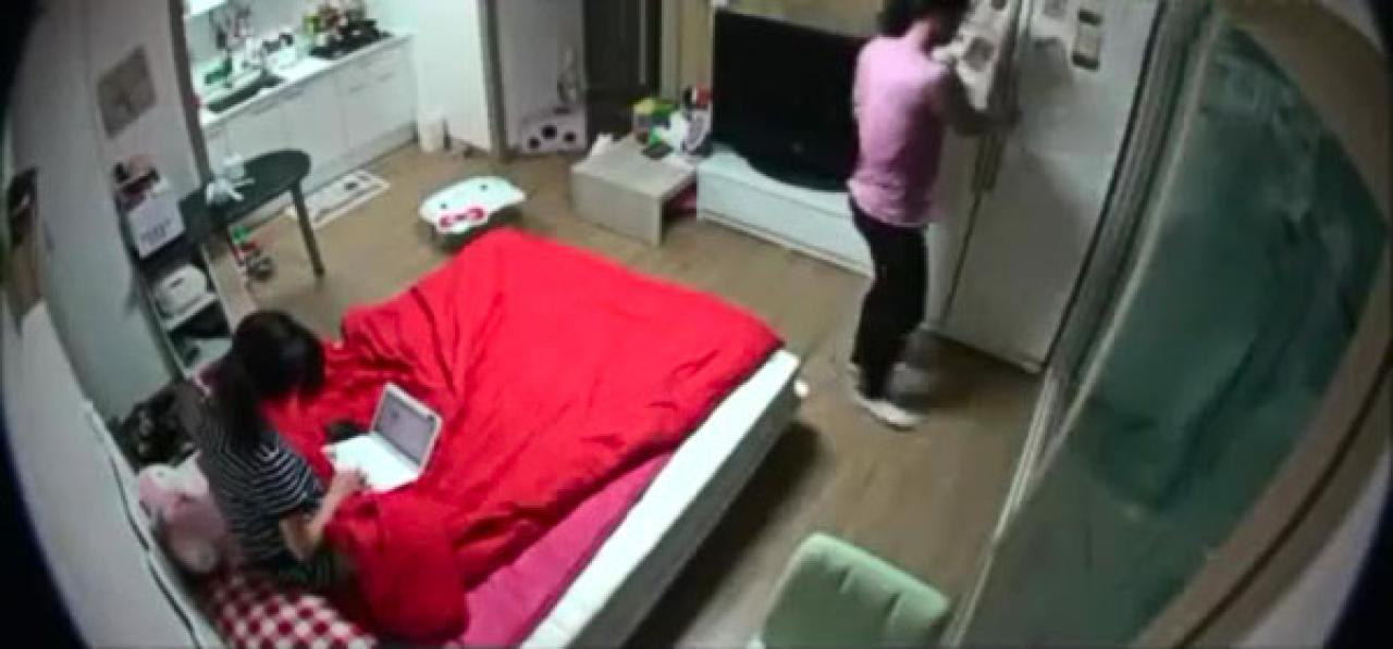 男友打开冰箱，寻找早饭的食材，女友坐在床上玩电脑