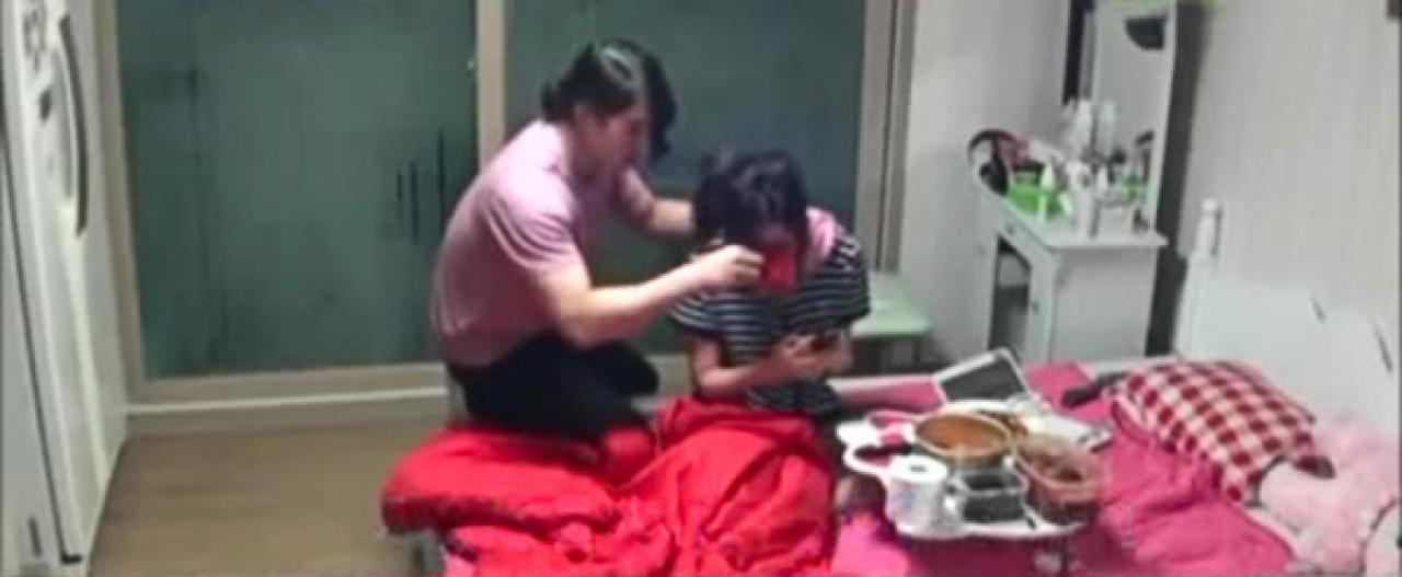 男友一手搭在女友肩膀上，另一只手拿着杯子，小心翼翼地喂女友喝水：慢点喝，别呛着