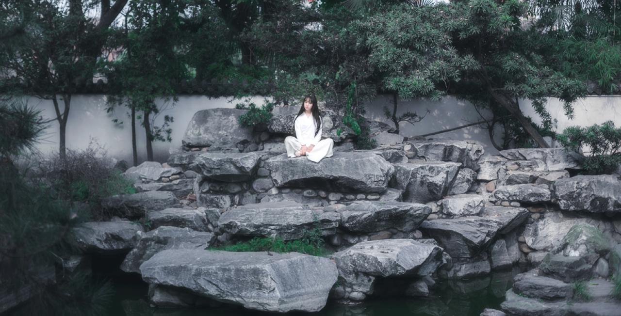 七七盘腿坐在石凳上