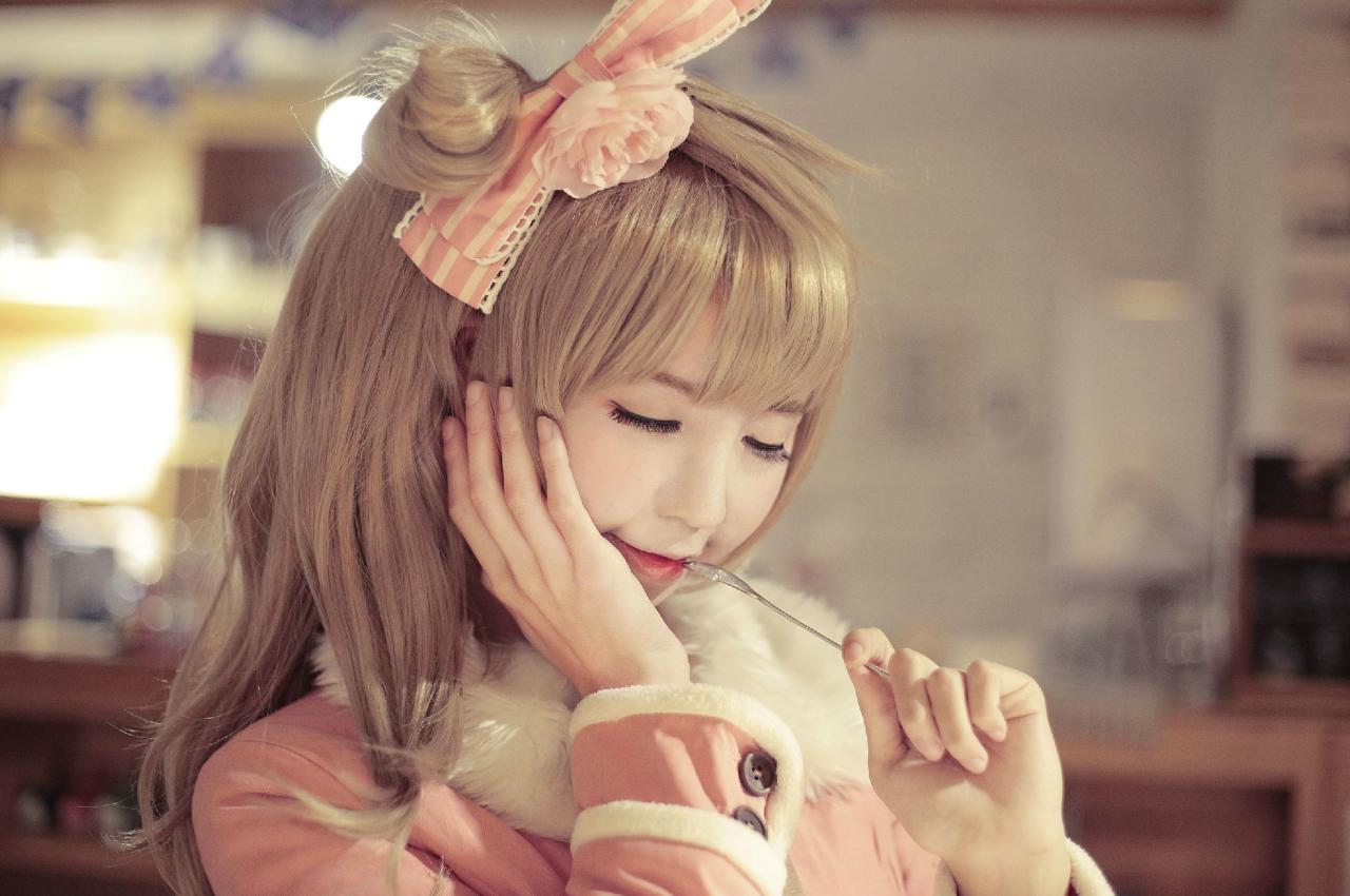 赤澤Aki扮南小鸟右手扶着脸庞，低着头，轻咬勺子