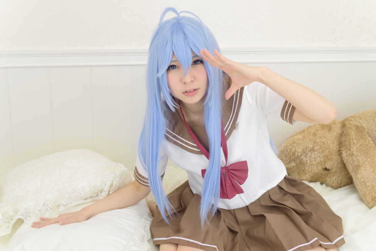 まゆふぁむ扮藤和艾莉欧右手扶着枕头，左手敬礼