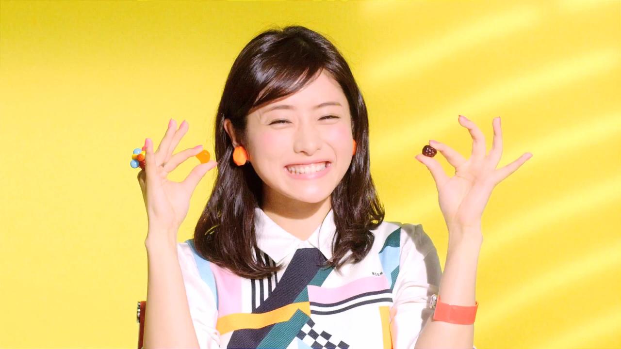 左手拿着葡萄味果汁软糖，右手拿着甜橙味果汁软糖，龇牙微笑的石原里美表情