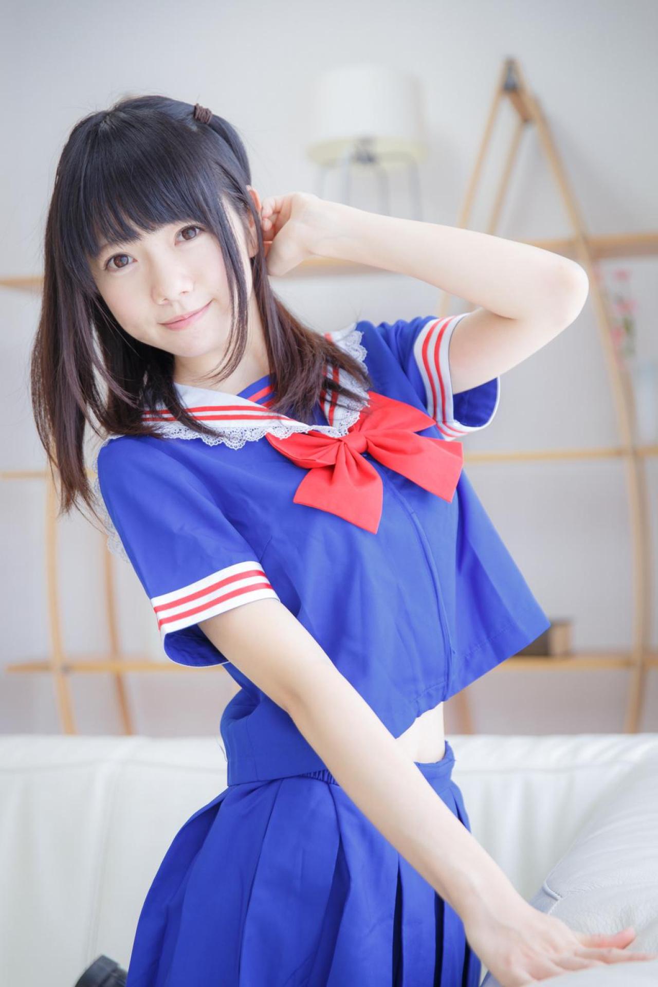 あっきん跪坐在沙发上，轻抚发梢