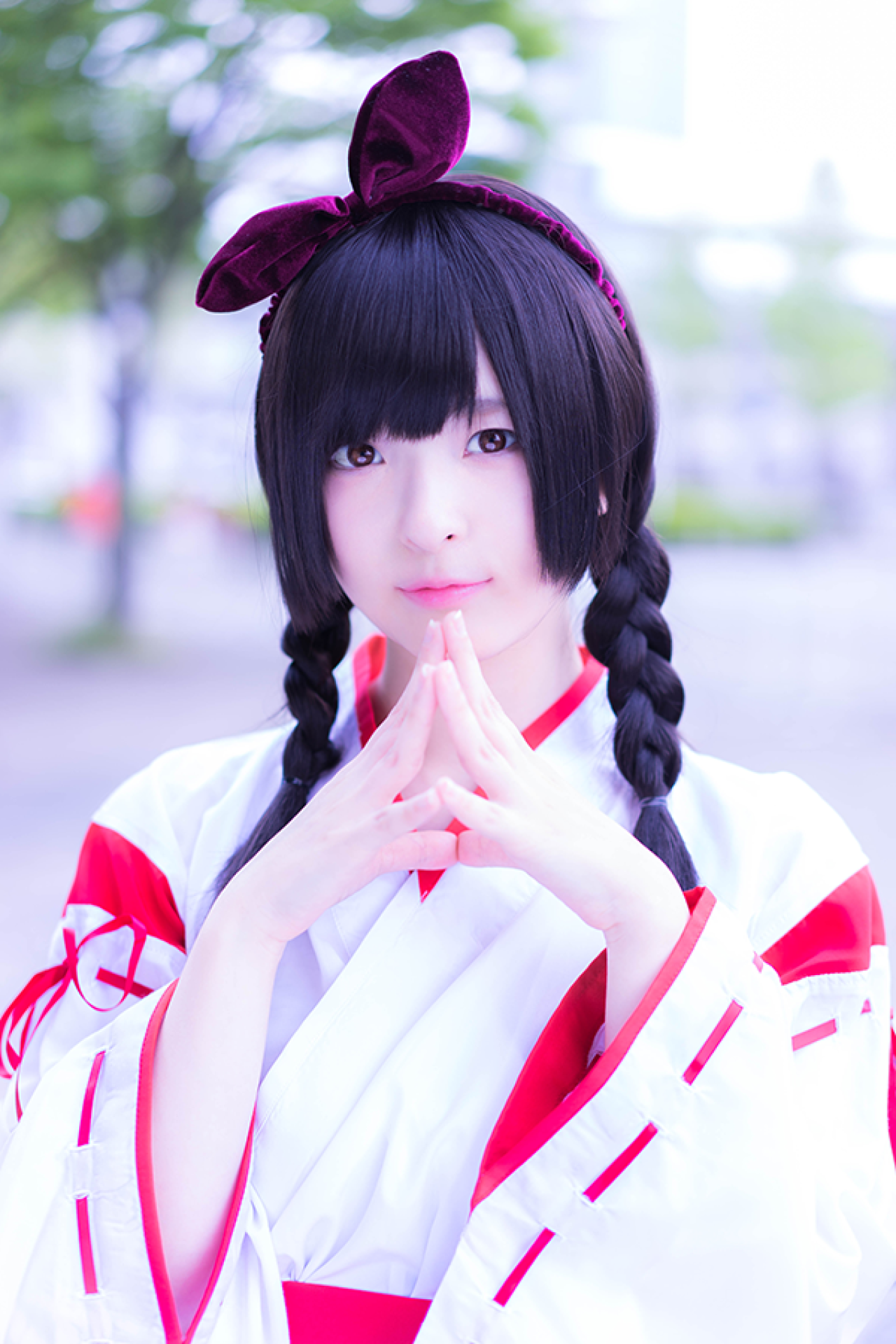 肉球あやと双手五指相抵放在脖颈前，微笑站立，上半身照