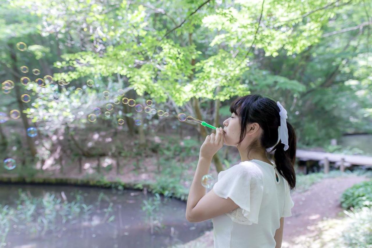 まいあむさん在湖边45度角仰望，吹出一连串的泡泡