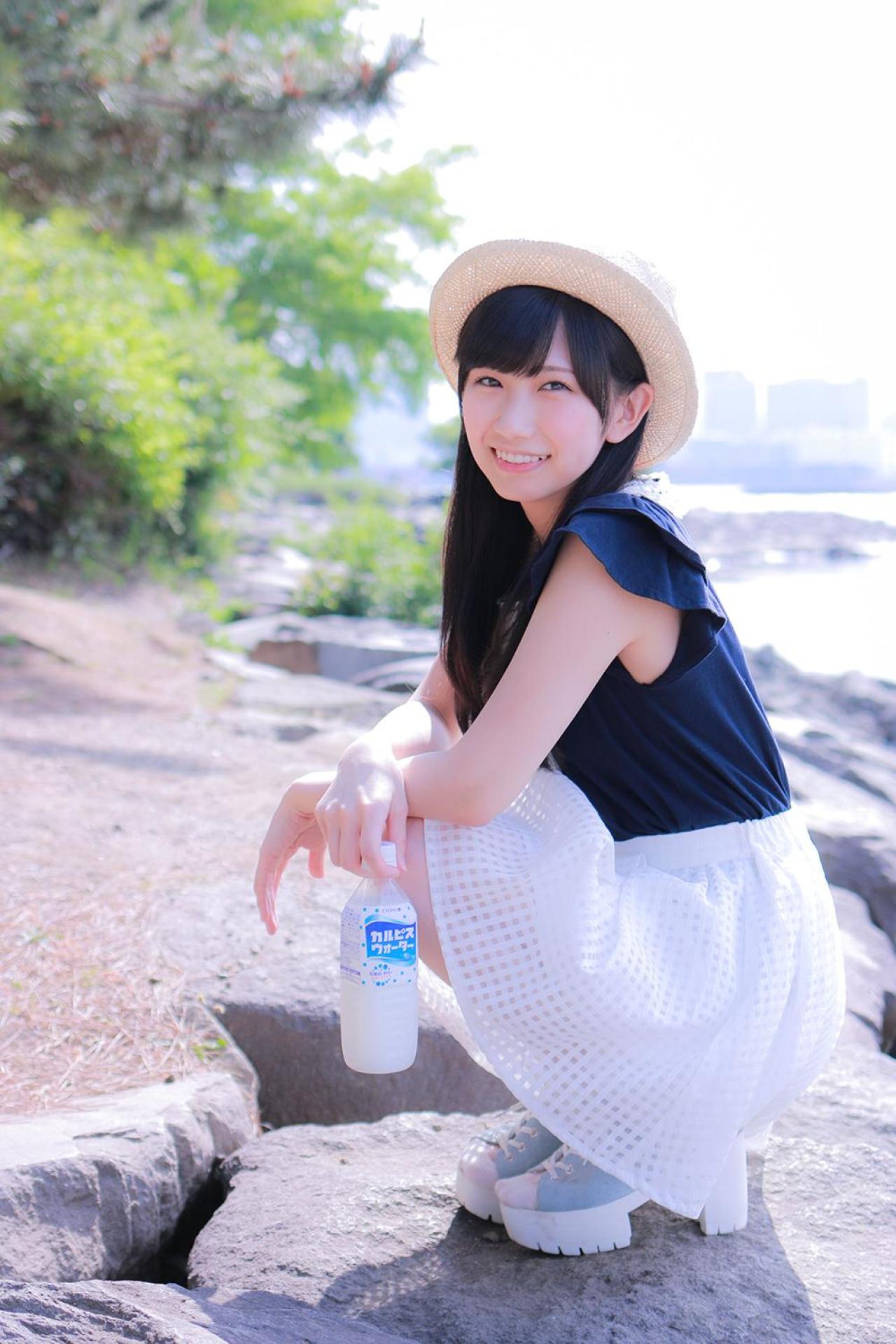 小日向くるみ拎着可尔必思饮料蹲在河边微笑