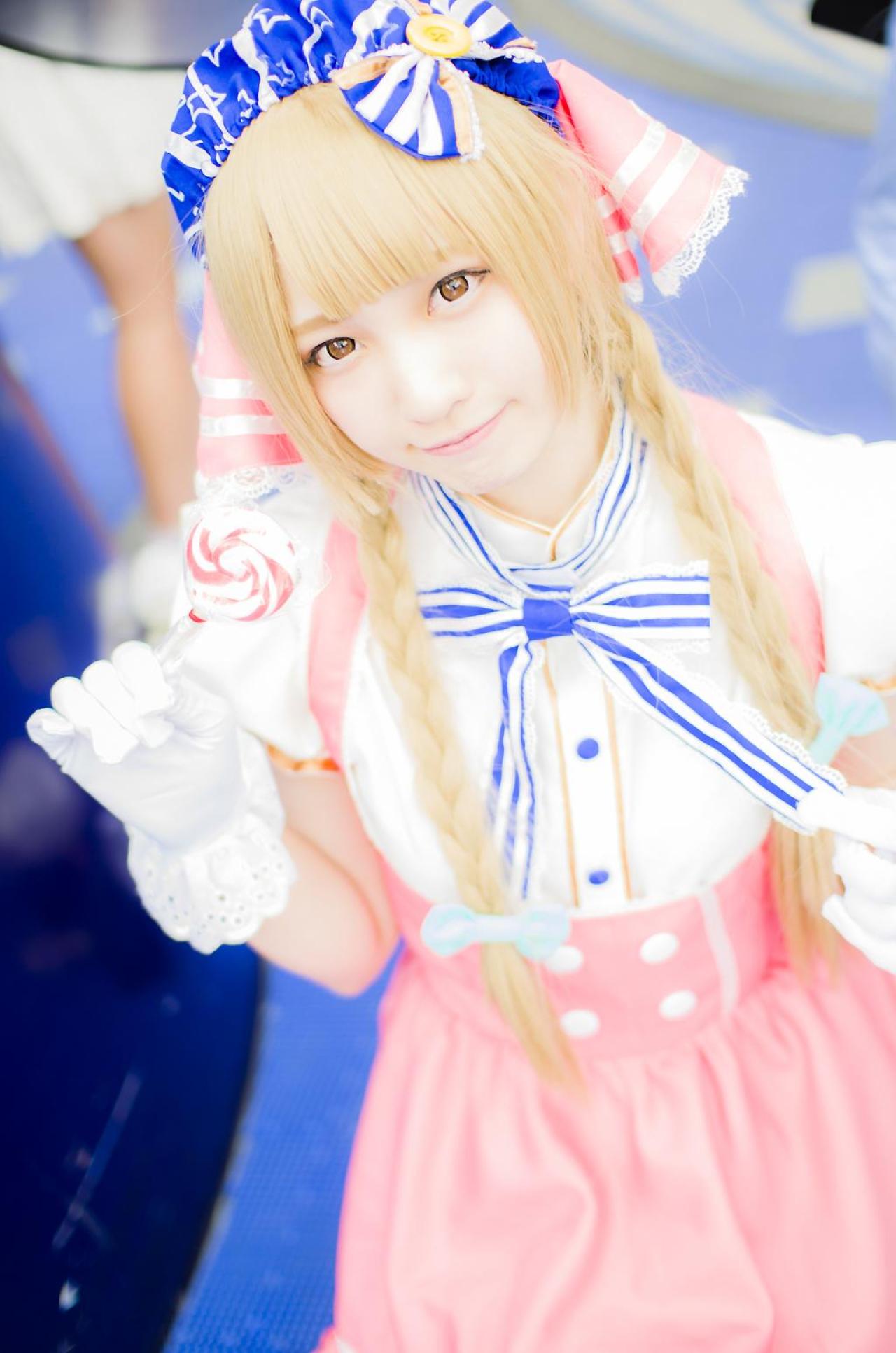 玖音さん扮南小鸟右手拿着棒棒糖，左手捏着马尾辫