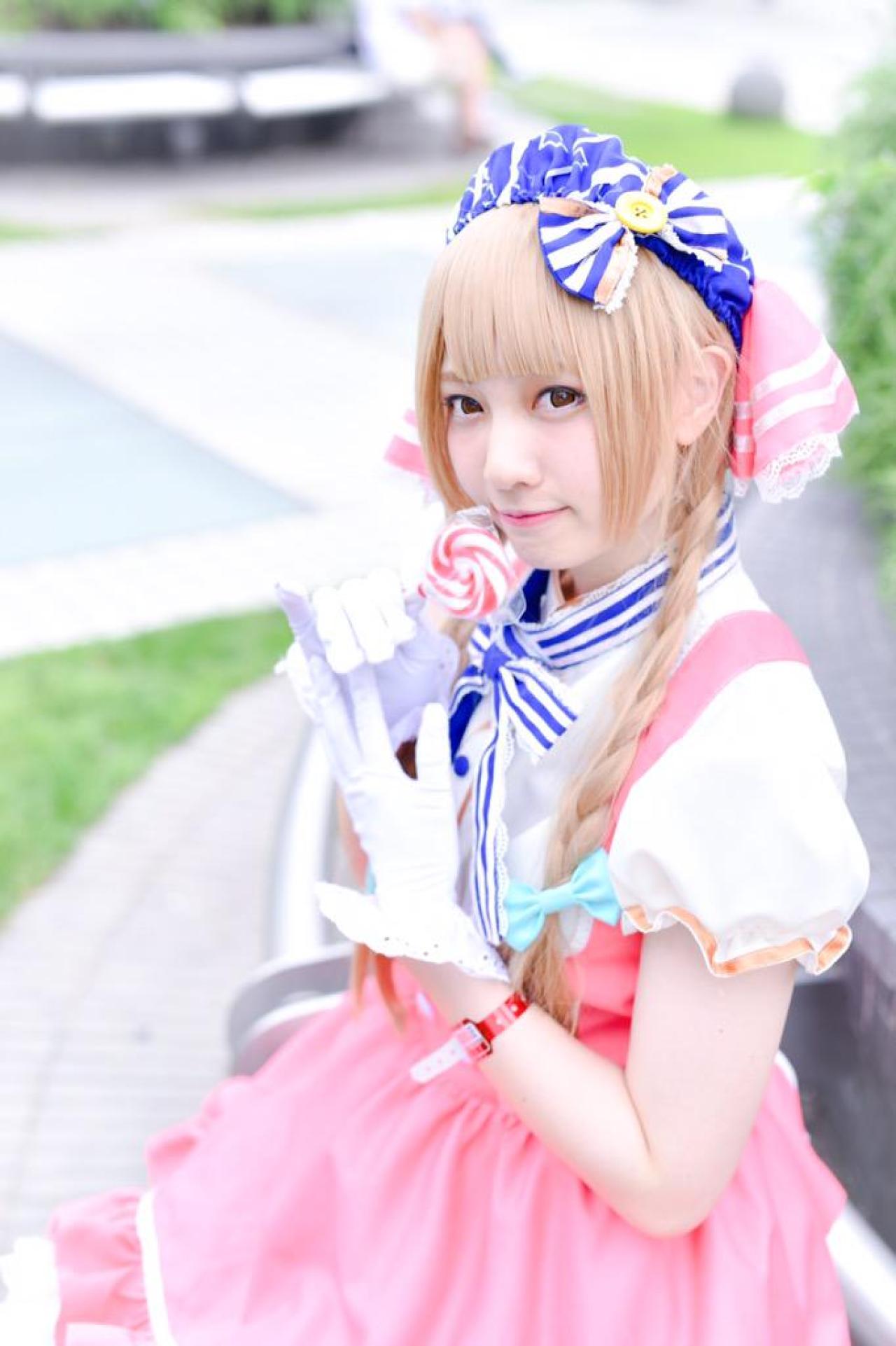 玖音さん扮南小鸟右手拿着棒棒糖侧身坐在栏杆上