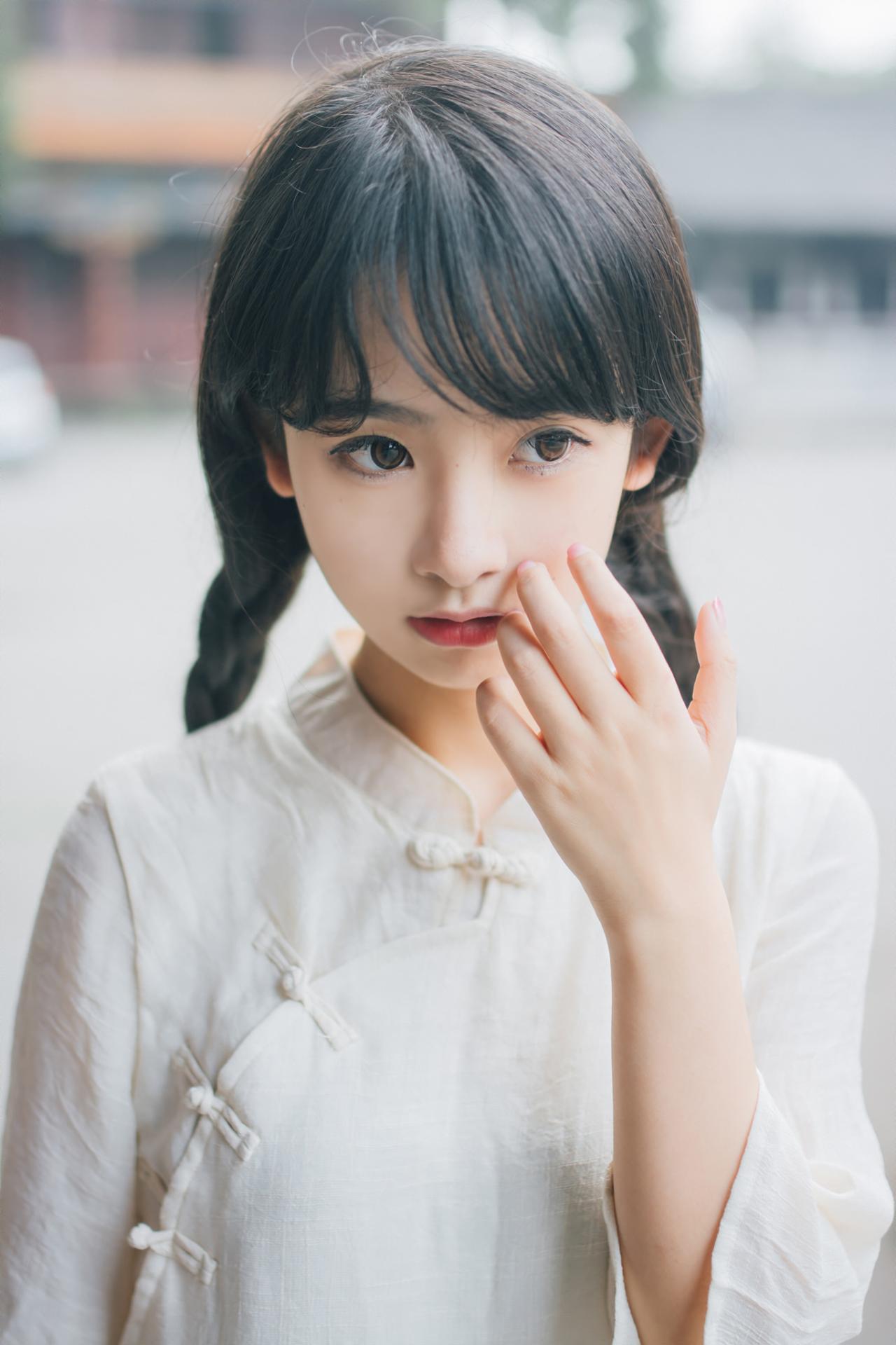 巫京蔓左手轻抚脸颊上半身照