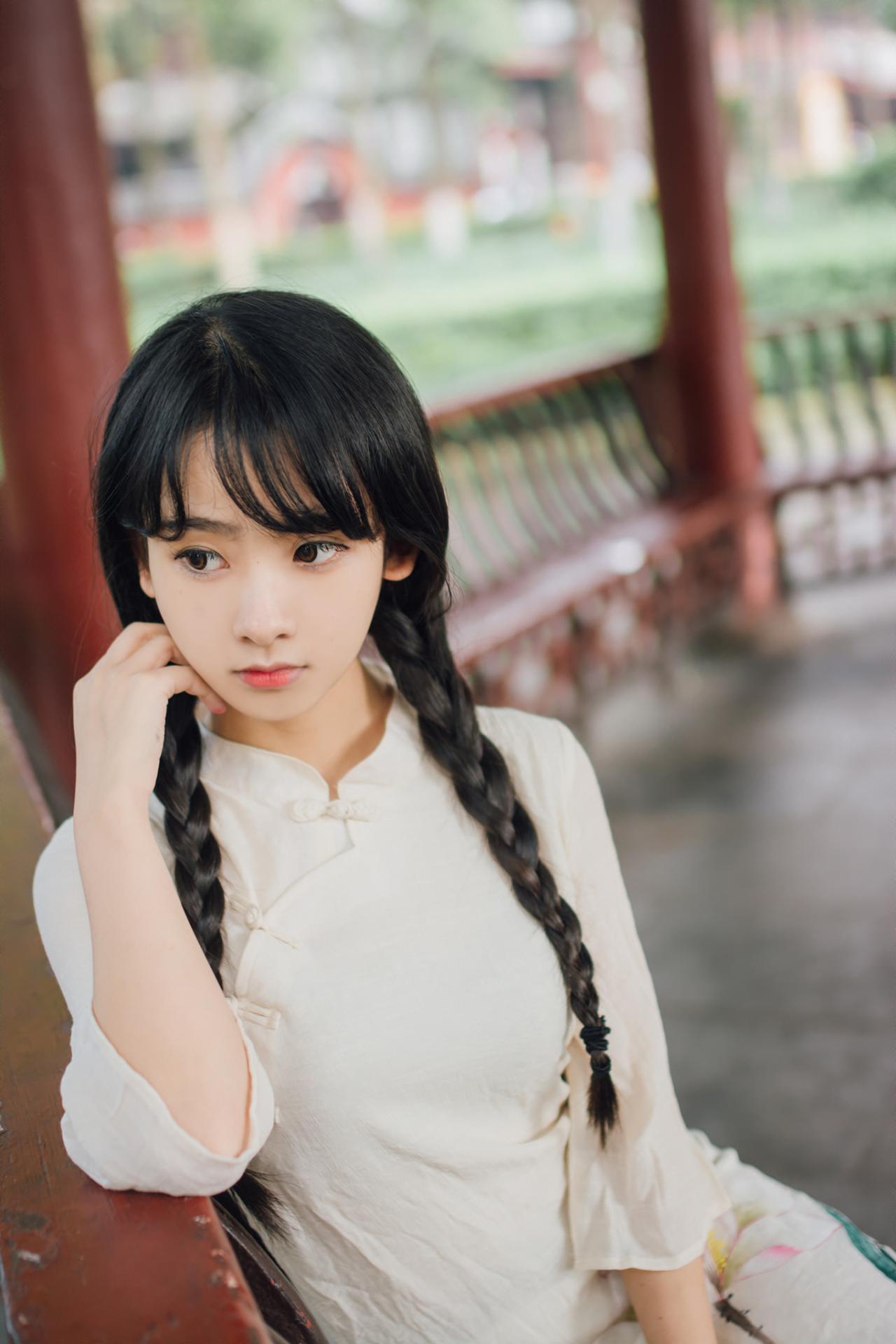 巫京蔓轻倚围栏手抵脸颊上半身照
