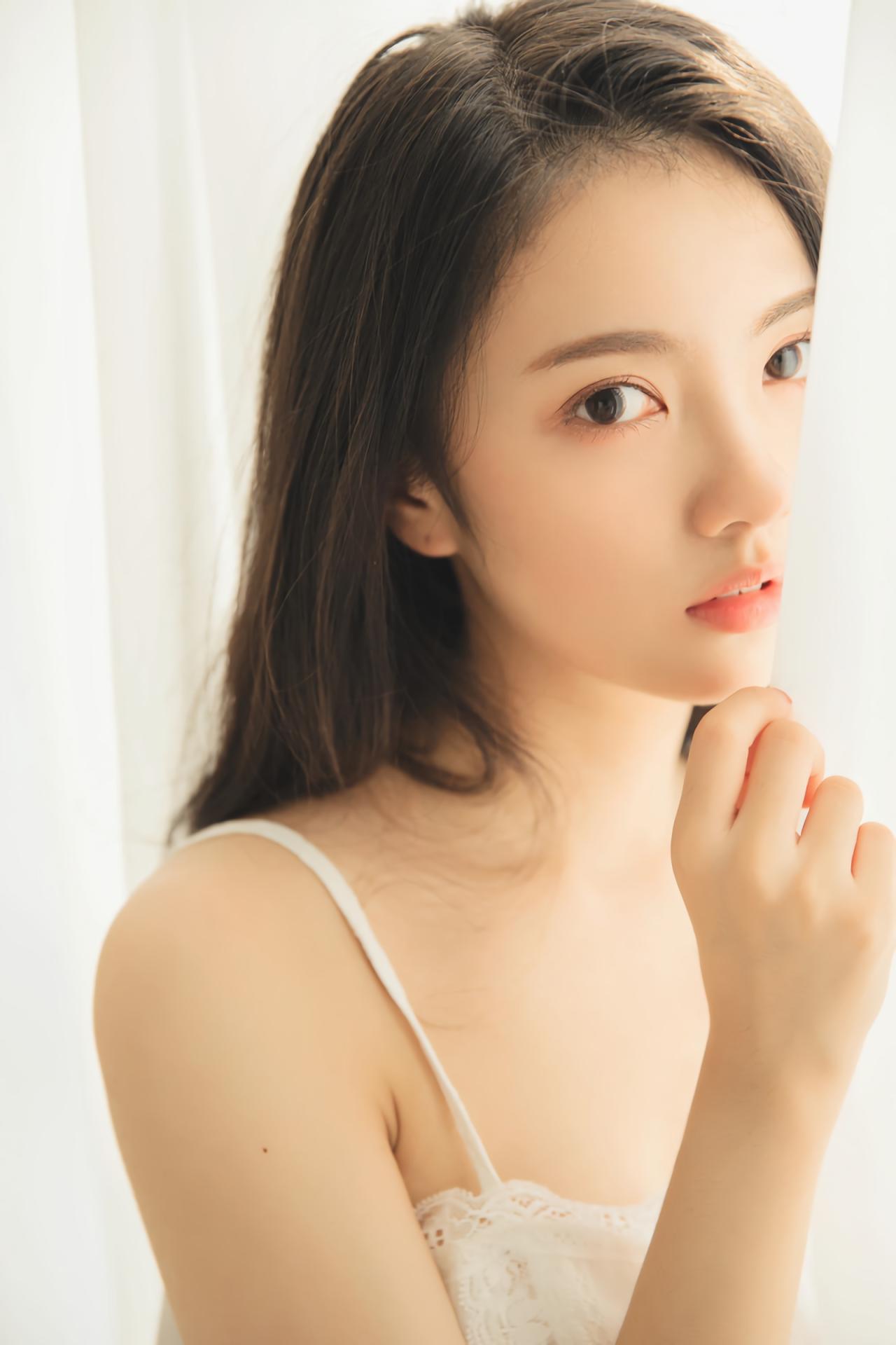 少女站在窗帘背后