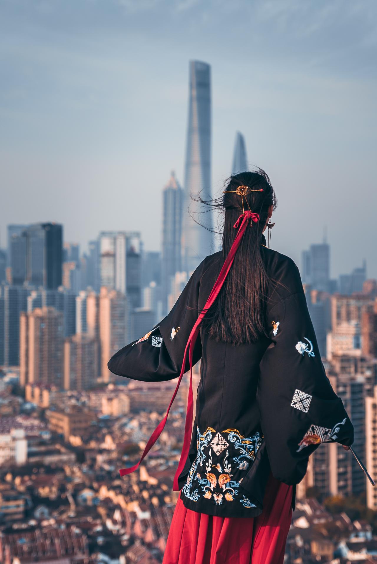 摩天大楼身穿汉服古装的女背影