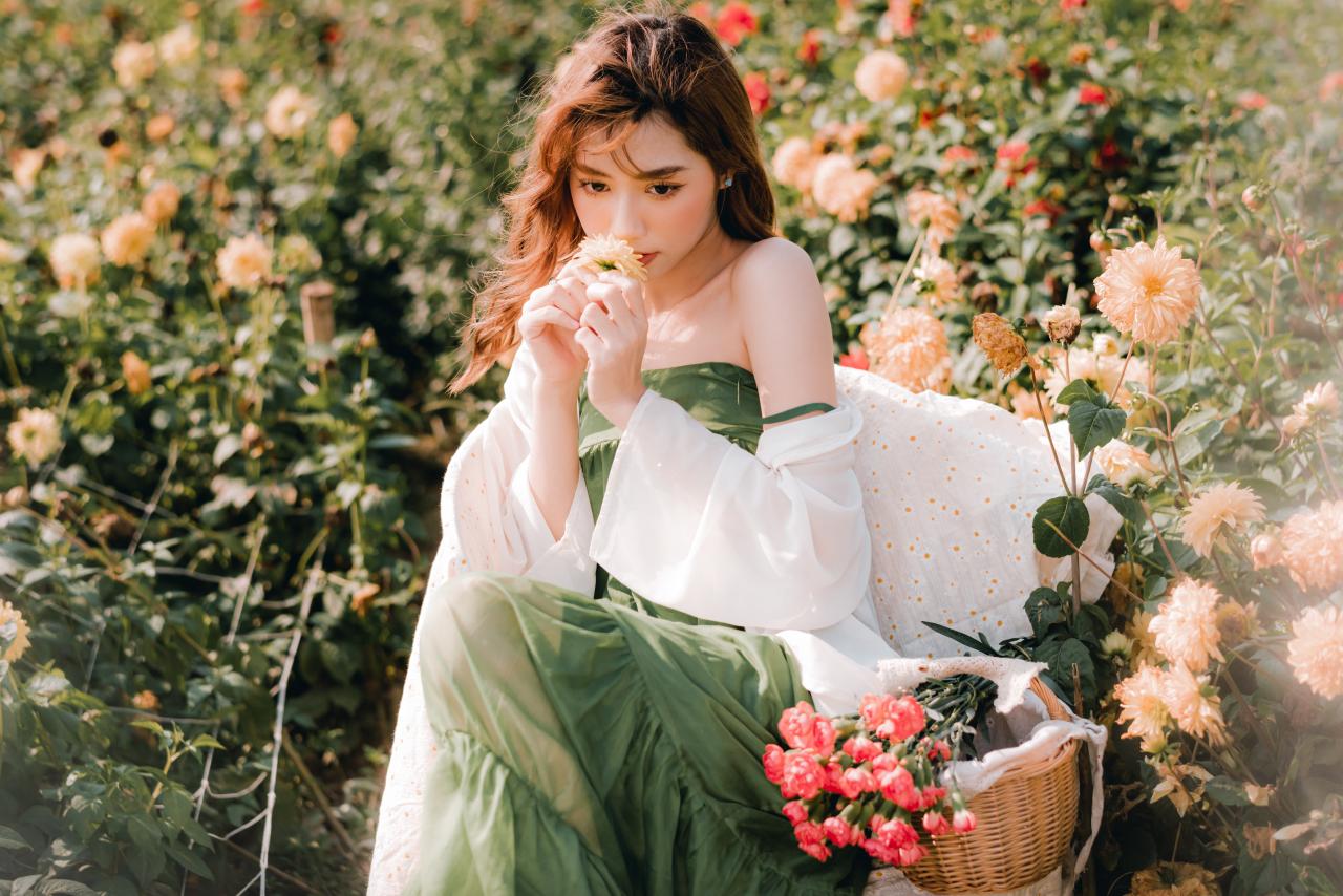 双手捧着大丽花菊花到唇边 绿色抹胸连衣裙 白色小菊花披肩 棕色长发少女 3/4侧面照 坐姿